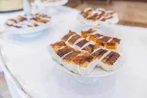 Assorted pastries with flaky crusts and golden tops arranged on white platters. jigsaw puzzle