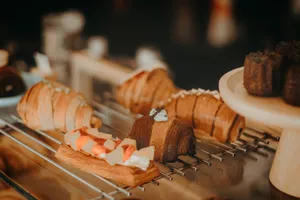 Gourmet pastries including croissants and dessert bars beautifully displayed on a rack. jigsaw puzzle