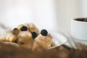 Close-up of flaky croissants topped with fresh blueberries, perfect for breakfast. jigsaw puzzle