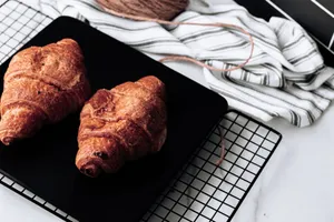 Delicious croissants resting on a cooling rack, perfect for breakfast and brunch photoshoots. jigsaw puzzle