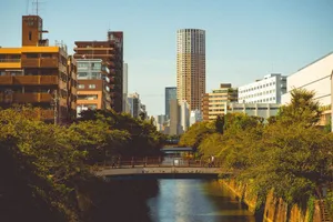 Explore the beauty of Tokyo's Meguro River framed by urban architecture and lush greenery in summer. jigsaw puzzle