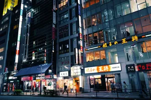 Dynamic urban street in Tokyo at night, featuring illuminated modern buildings and pedestrians. jigsaw puzzle