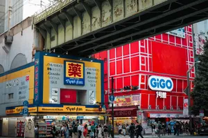 Vibrant street scene in Tokyo showcasing GIGO and Matsumoto KiYoshi stores under an overpass. jigsaw puzzle
