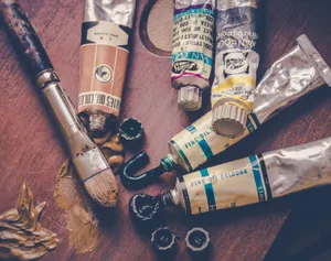 Close-up of oil paint tubes and brushes on a wooden surface, perfect for creative projects. jigsaw puzzle