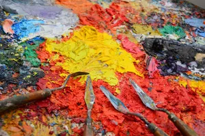 Close-up of a colorful artist's palette with spatulas and vibrant mixed paints. jigsaw puzzle