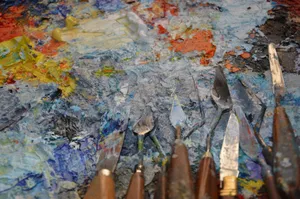 Vivid and textured palette loaded with oil paint, featuring various artist's palette knives. jigsaw puzzle