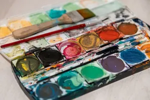 Vibrant watercolor paints and brushes artistically arranged, showcasing creativity and color variety. jigsaw puzzle