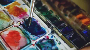 Close-up of a watercolor palette with vibrant paints and a paintbrush in action. jigsaw puzzle