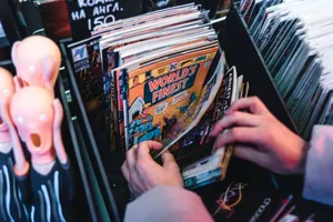 Hands sorting through vintage comic books in a store, focusing on 'World's Finest.' jigsaw puzzle