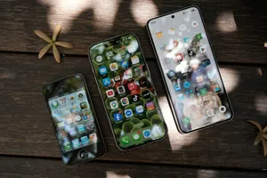 A collection of smartphones showing different app icons, placed on a wooden surface in natural light. jigsaw puzzle