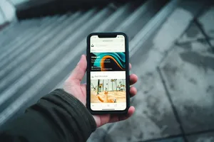 A person holds a smartphone while browsing a webpage outdoors. Urban setting. jigsaw puzzle