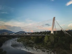 Stunning view of a cable-stayed bridge spanning over a river with scenic background. jigsaw puzzle