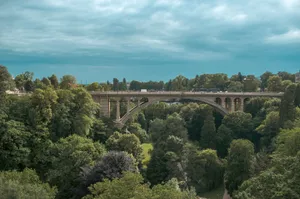 Stunning view of Adolphe Bridge surrounded by vibrant greenery in Luxembourg City. jigsaw puzzle