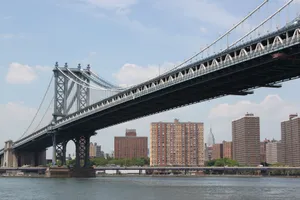 View of the Manhattan Bridge spanning the East River with New York City skyline in the background. jigsaw puzzle