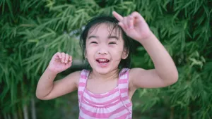 A cheerful young girl in a striped top enjoying summer playtime outdoors. jigsaw puzzle
