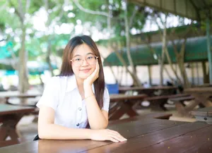 Cheerful young woman sitting outdoors at a picnic table, enjoying leisure time. jigsaw puzzle
