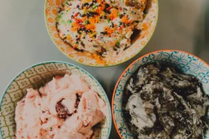 Top view of three colorful bowls filled with various ice cream flavors and toppings. jigsaw puzzle