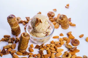 Scoops of almond fig ice cream in a glass bowl surrounded by almonds and figs. jigsaw puzzle