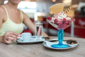 Appetizing berry ice cream sundae with waffle cone, served with coffee in a modern cafe. jigsaw puzzle