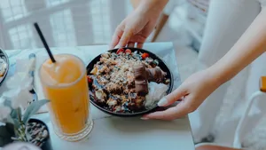 Hands placing a dessert bowl with chocolate and whipped cream next to a glass of orange juice. jigsaw puzzle