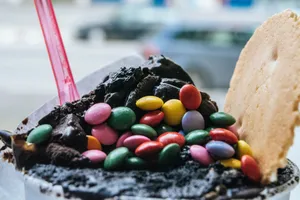 Close-up of a chocolate ice cream topped with multicolored candies and a waffle wafer. jigsaw puzzle