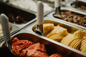 A vibrant display of colorful gelato flavors in metal trays at an ice cream shop. jigsaw puzzle