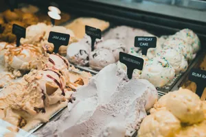 A colorful selection of ice creams showcases diverse flavors like blueberry and birthday cake in a display cabinet. jigsaw puzzle