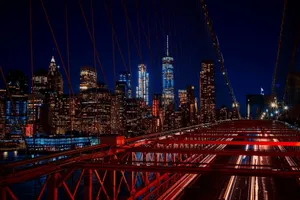 A breathtaking night view featuring the New York City skyline and iconic Brooklyn Bridge illuminated in vibrant colors. jigsaw puzzle