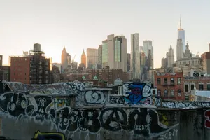 View of New York City skyline from a graffiti-covered rooftop at sunset. jigsaw puzzle