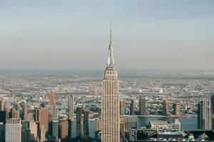 Picturesque skyline of New York City with famous skyscraper with spire and multistory buildings against cloudy sky jigsaw puzzle