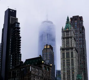 A dramatic view of New York City skyscrapers enveloped in fog, featuring iconic architecture. jigsaw puzzle