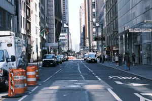 Street view in New York City with vehicles, skyscrapers, and pedestrians on a sunny day. jigsaw puzzle