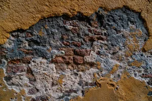 Close-up view of a weathered brick wall with peeling plaster and textured patterns. jigsaw puzzle