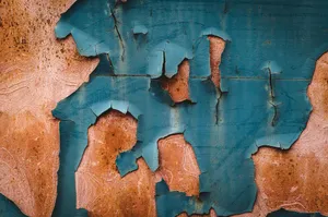 Close-up of blue peeling paint on a weathered concrete wall, showing patterns and texture. jigsaw puzzle