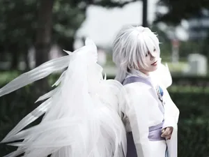 A graceful cosplay character with white wings and hair, posing outdoors in daylight. jigsaw puzzle