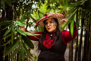 A woman in a fashionable red outfit and hat stands amidst bamboo, creating a vibrant portrait. jigsaw puzzle
