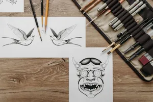Top view of a creative workspace featuring ink drawings and various art tools on a wooden table. jigsaw puzzle