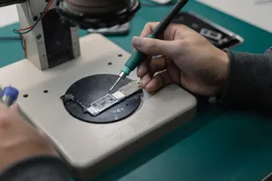 Detail view of hands soldering a circuit board in an electronics workshop. jigsaw puzzle