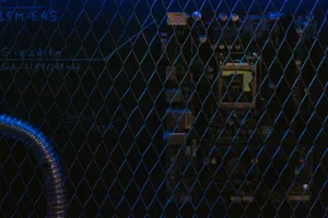 Artistic view of a circuit board through metal mesh with blue lighting. jigsaw puzzle