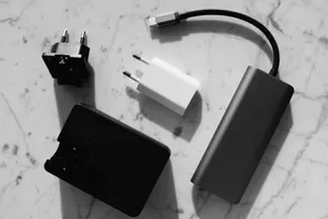 Flat lay of various electronic chargers on a marble surface with strong shadows. jigsaw puzzle