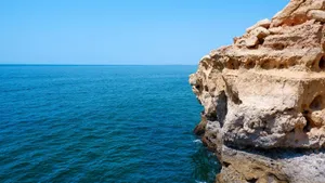 Breathtaking view of Algarve's limestone cliffs meeting the azure Atlantic Ocean under a clear sky. jigsaw puzzle