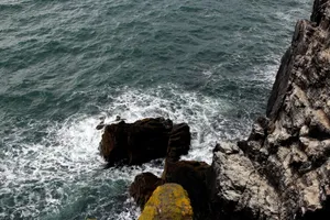 Dramatic ocean waves crashing against a rugged cliff coastline in Fife, Scotland, showcasing natural beauty. jigsaw puzzle