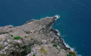 Stunning aerial shot of rugged coastline meeting deep blue ocean waters with rocky formations. jigsaw puzzle