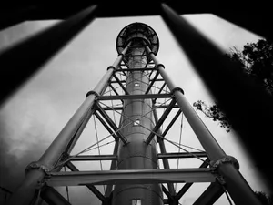 Dramatic black and white view of a towering industrial structure against the sky. jigsaw puzzle