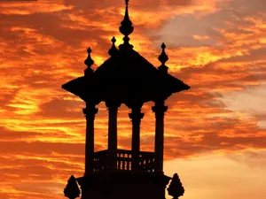 A striking silhouette of an ornate tower set against a vibrant, fiery sunset sky. jigsaw puzzle