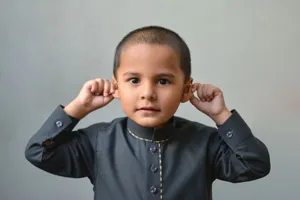 Charming portrait of a young boy in traditional attire playfully posing indoors. jigsaw puzzle