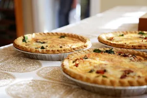 Delightful homemade quiches on a classic patterned tablecloth, inviting and delicious. jigsaw puzzle