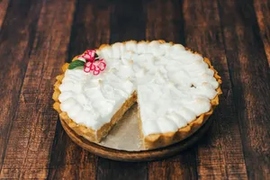 Close-up of a delicious creamy pie with flower decoration on wood. jigsaw puzzle