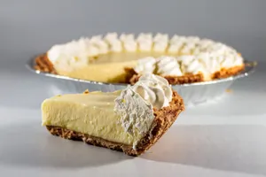 Close-up of a creamy cheesecake slice with whipped topping, perfect for dessert lovers. jigsaw puzzle