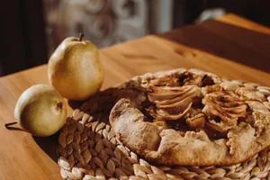 A delicious pear galette on a wooden table, embodying autumn warmth. jigsaw puzzle